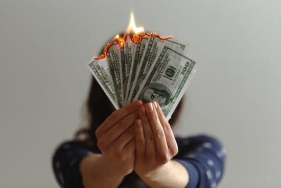 girl holding money on fire