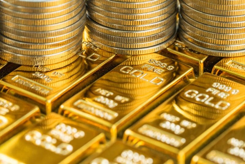 gold coins on top of gold bars gold coins on top of gold bars